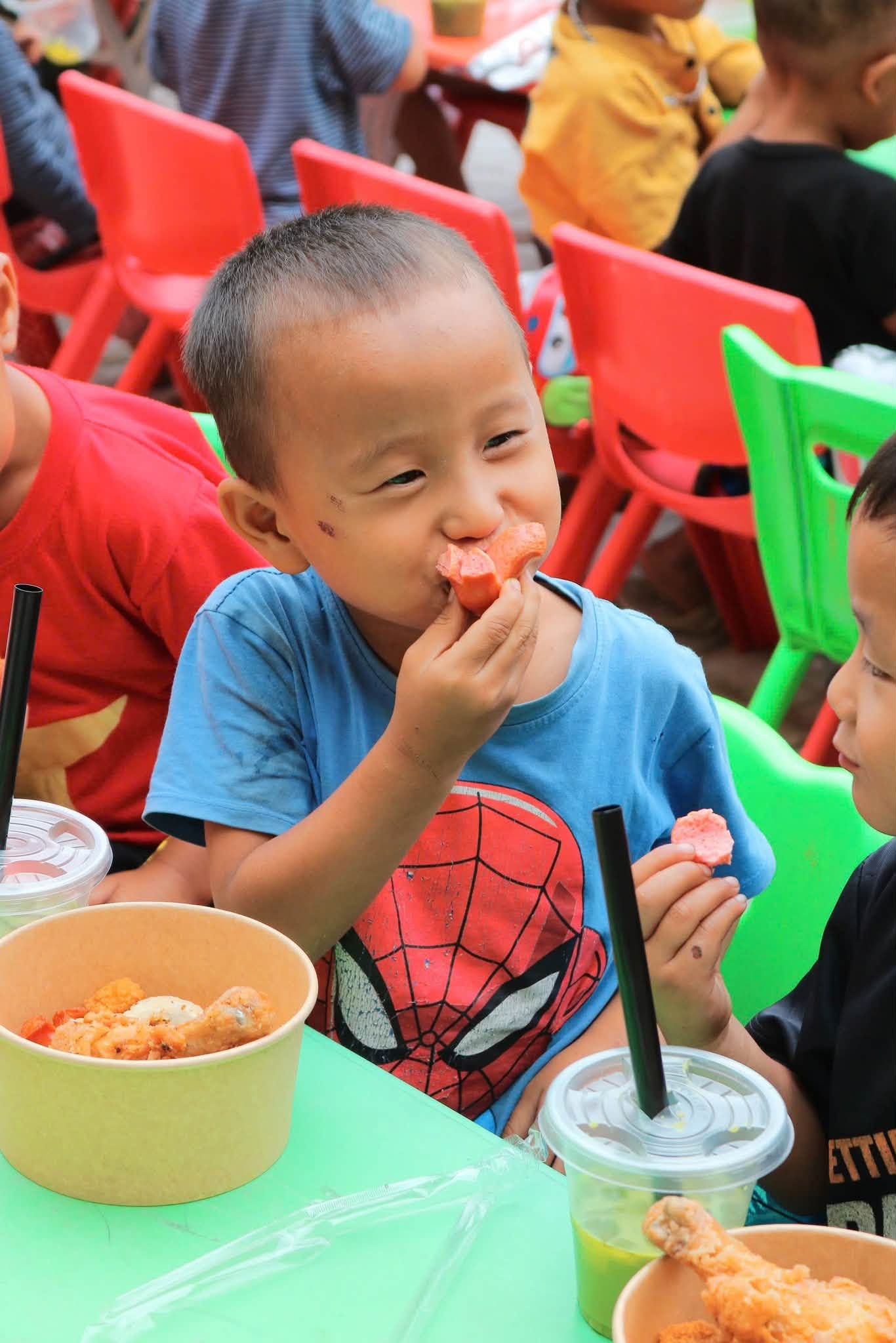 Em nhỏ cười tươi thưởng thức bữa ăn nóng
