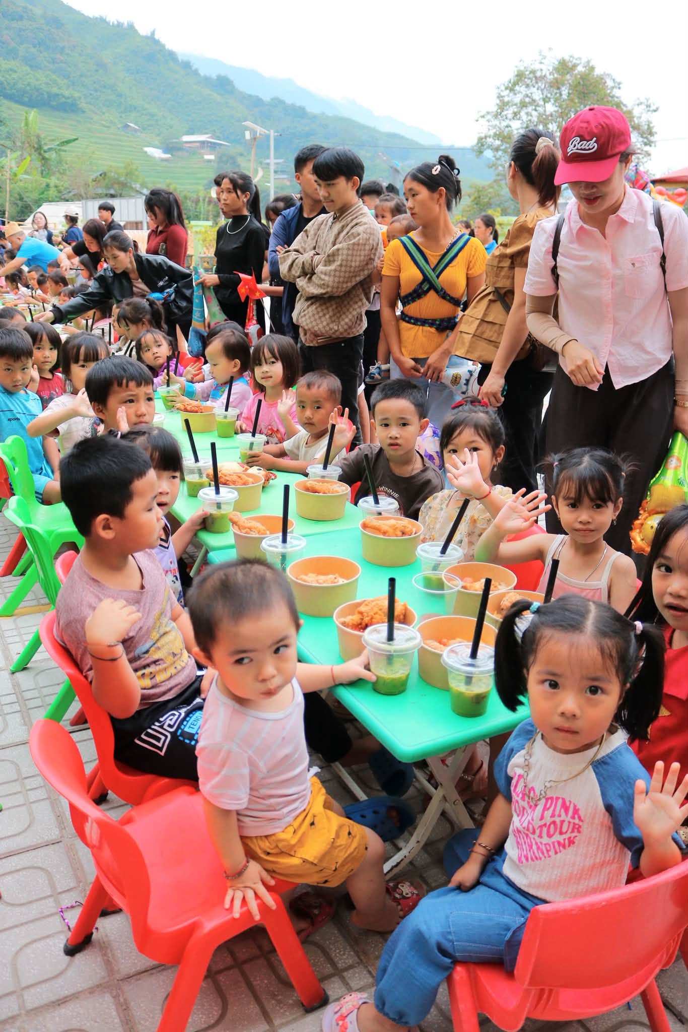 Em nhỏ ngồi dùng bữa tại bàn ghế nhỏ