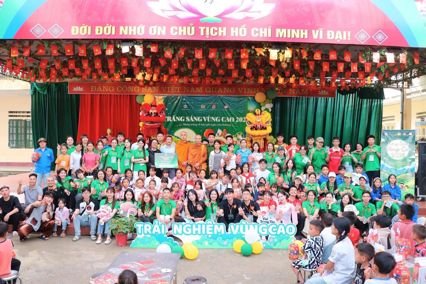 Tập thể tình nguyện viên và các em nhỏ chụp ảnh trên sân khấu Trăng Sáng Vùng Cao